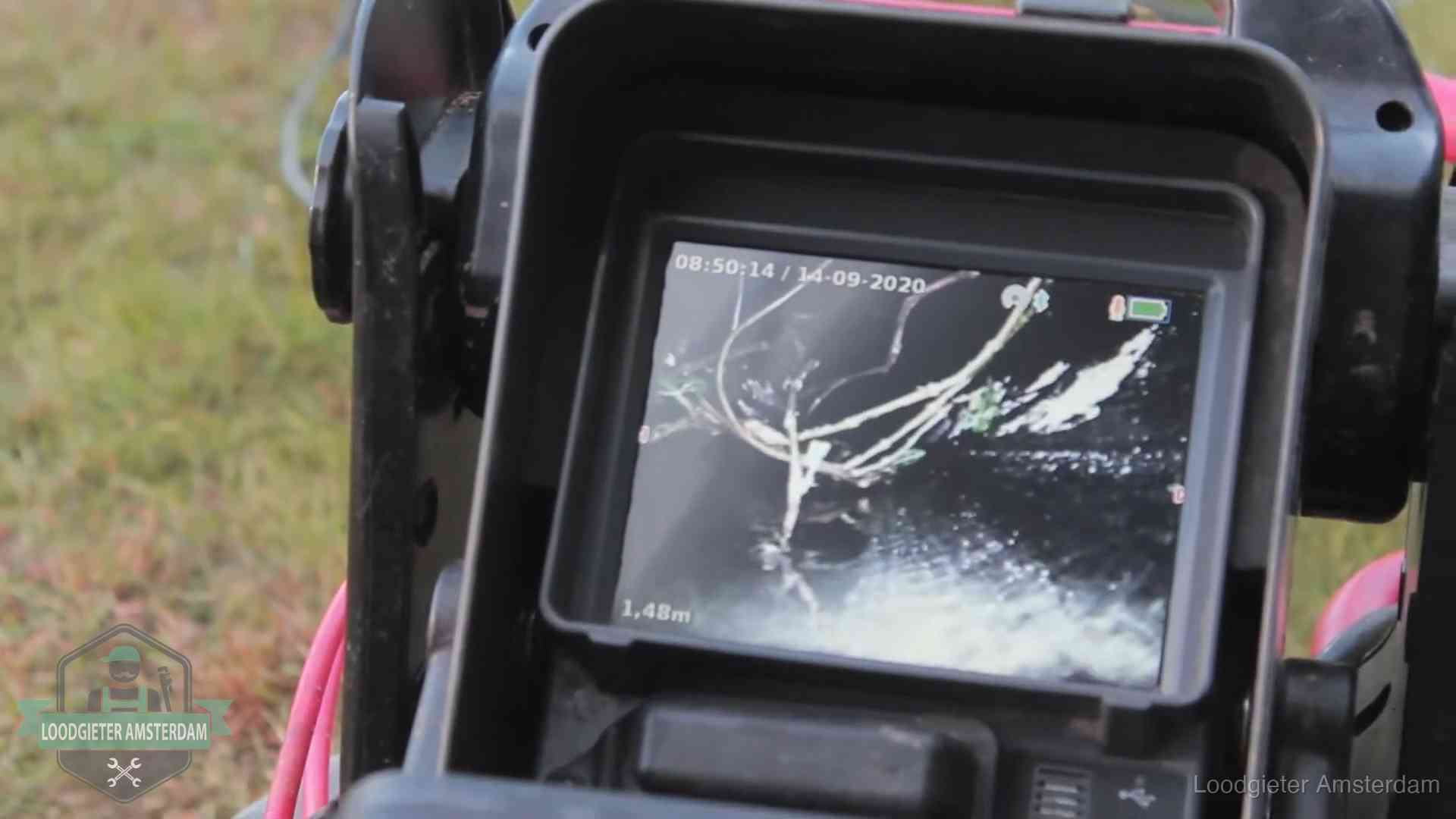 Monitor van een rioolcamera toont wortelingroei in de rioolbuis bij een woning in Amsterdam