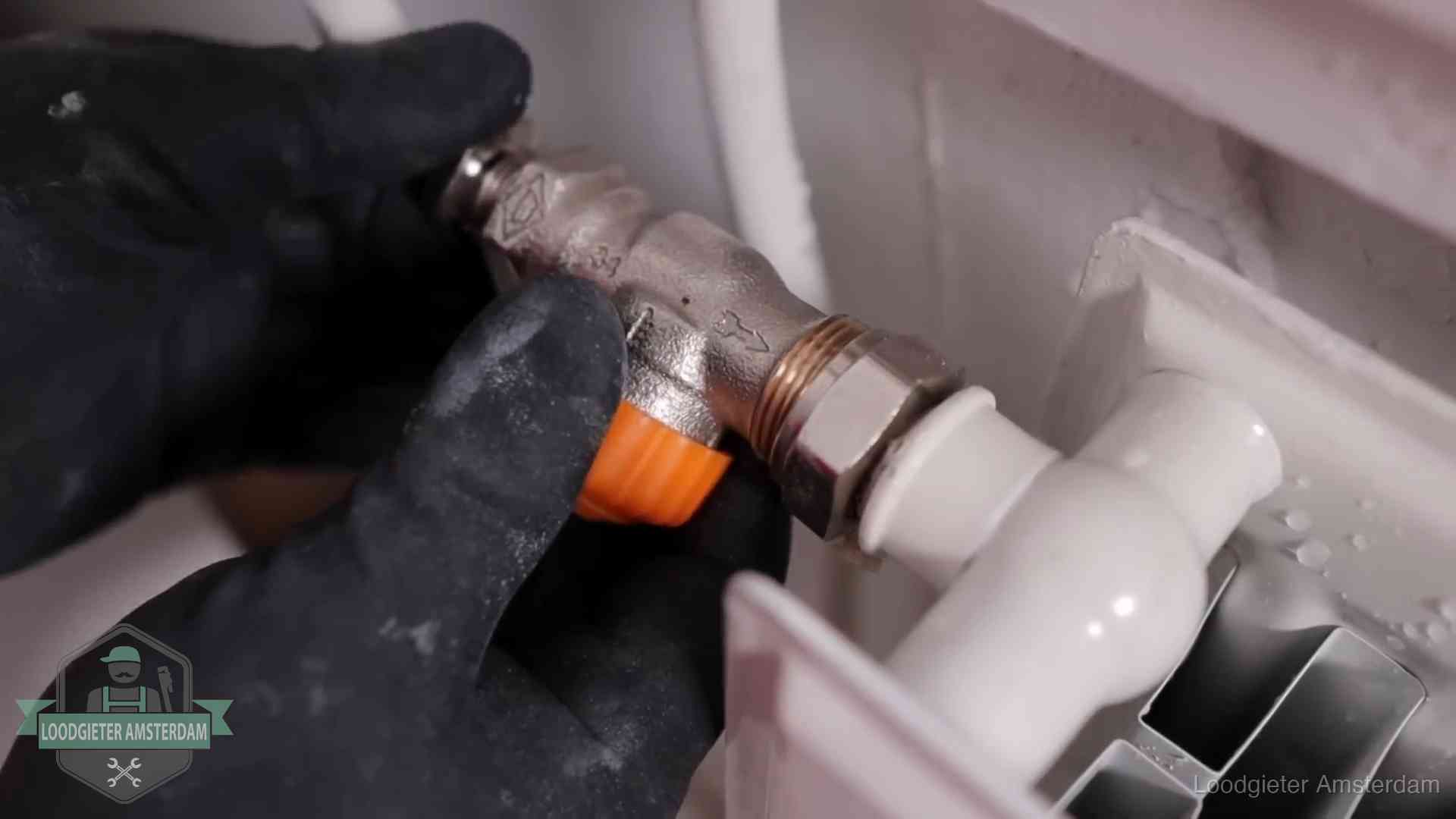 Je cv winterklaar maken in Amsterdam Thermostaatkraan wordt gemonteerd op een radiator in Amsterdam voor het stookseizoen