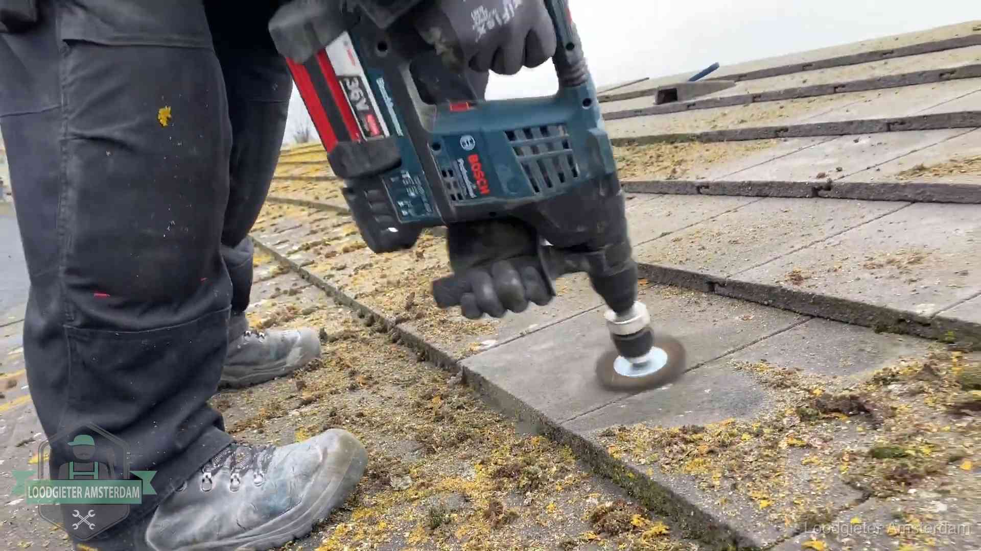 Betonnen dakpannen worden machinaal gereinigd tijdens dakonderhoud in Amsterdam
