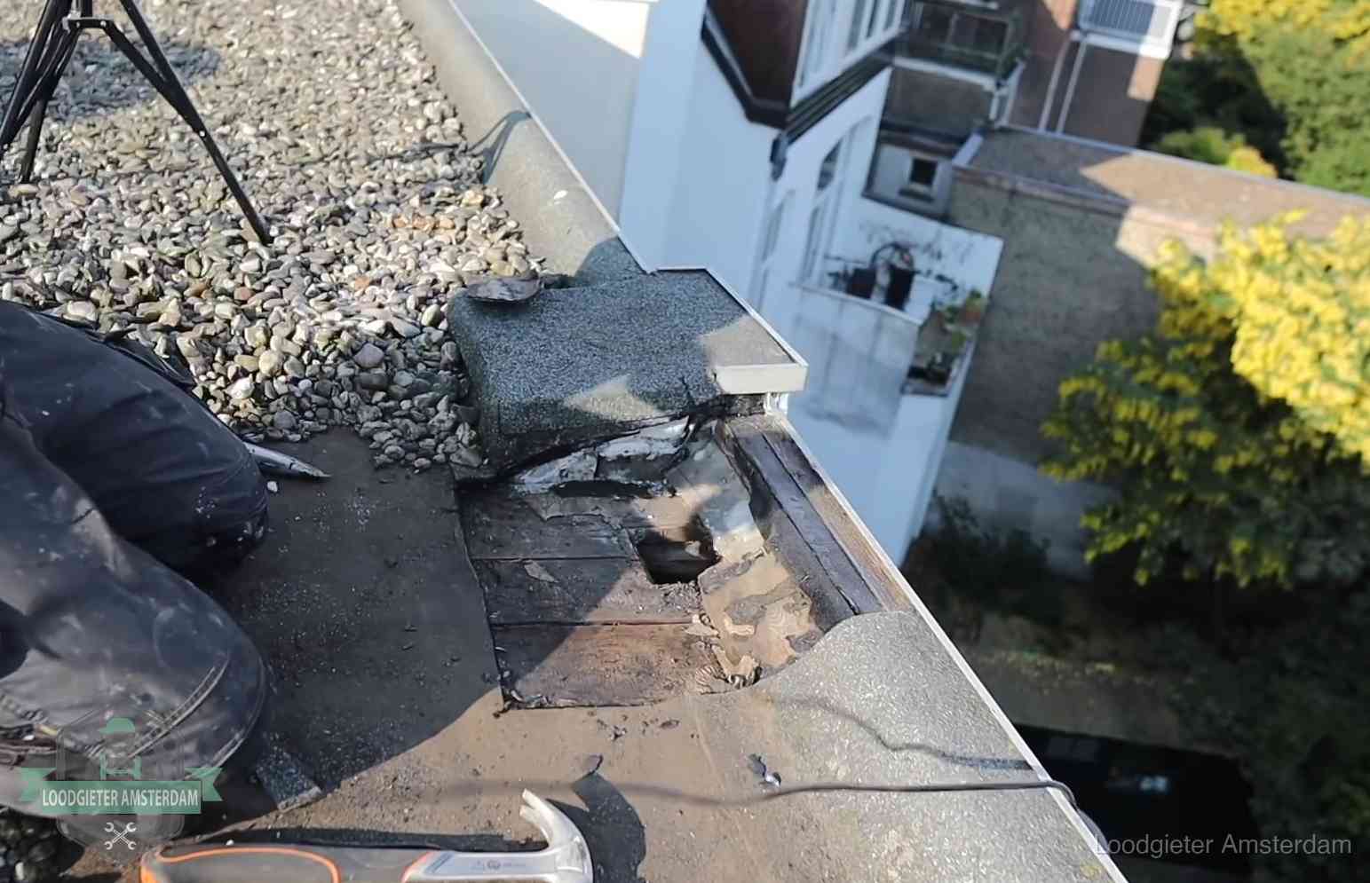 Opengelegde dakrand met verrot dakbeschot door een langdurige daklekkage in Amsterdam