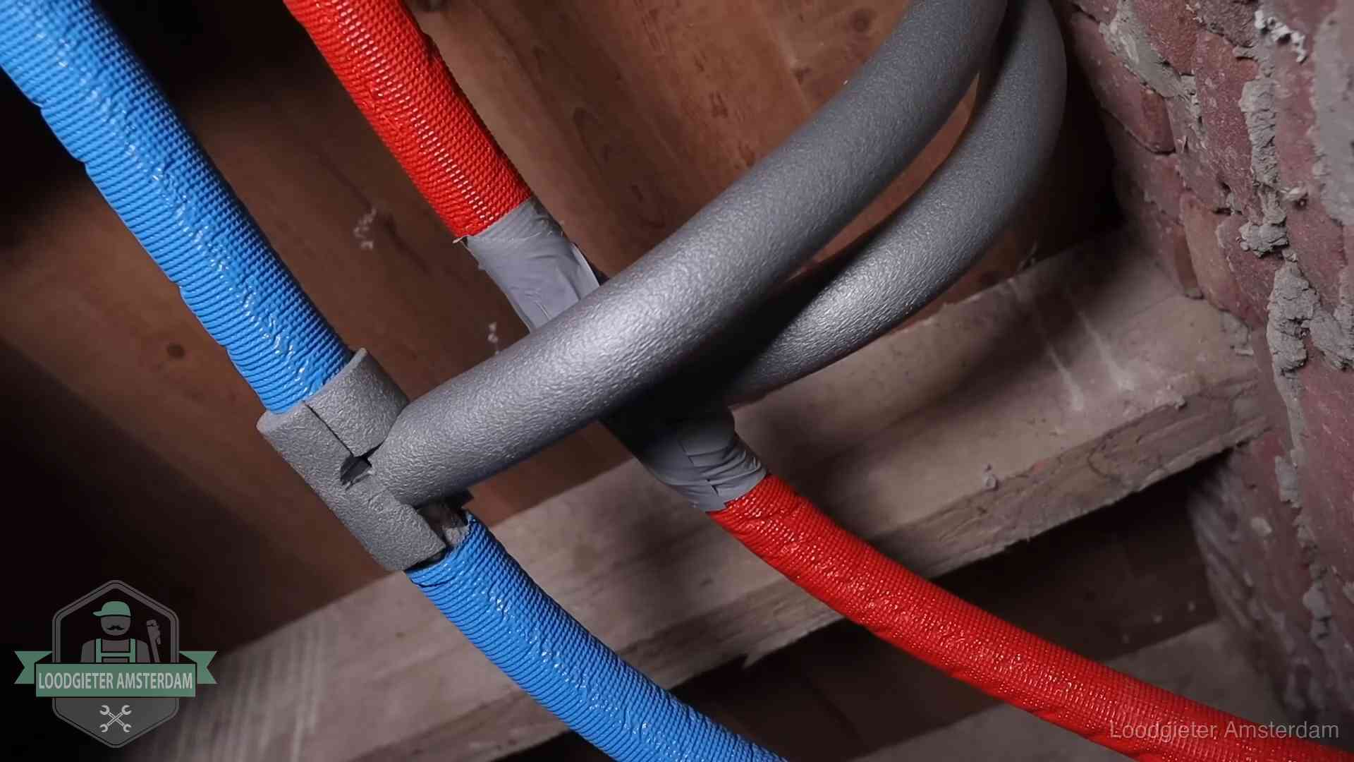 Bevroren leidingen voorkomen in Amsterdam Geïsoleerde waterleidingen langs houten balken tegen bevriezing in Amsterdam