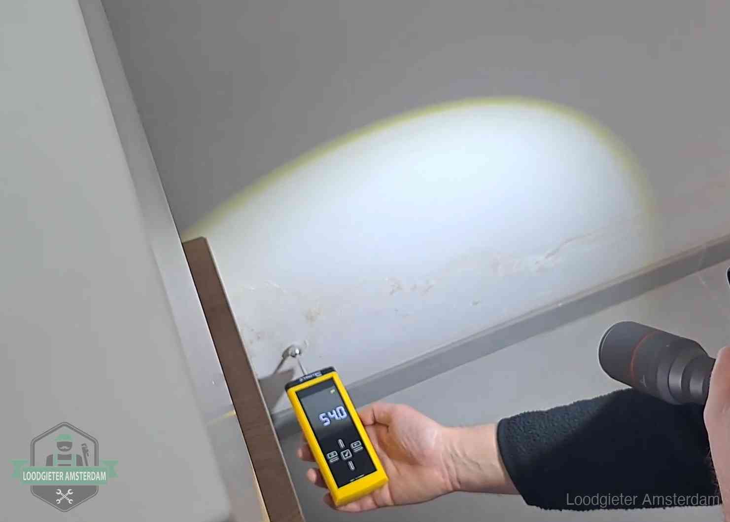 Lekdetectie-technieken in Amsterdam Vochtmeter tegen een natte wand met lekkagesporen in Amsterdam