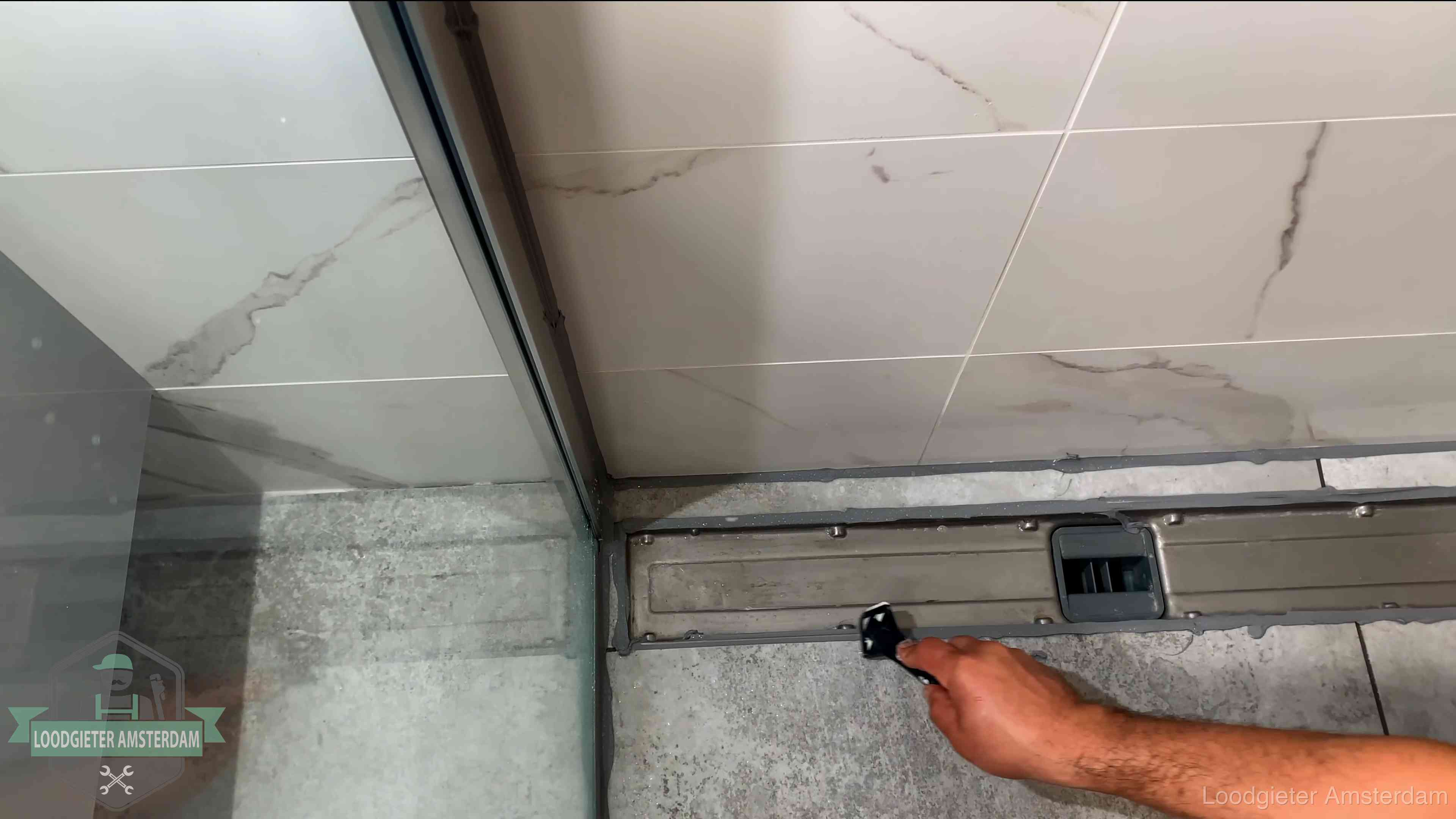 Lekkage in de badkamer verhelpen in Amsterdam Verse kitrand langs de douchegoot in een betegelde badkamer in Amsterdam