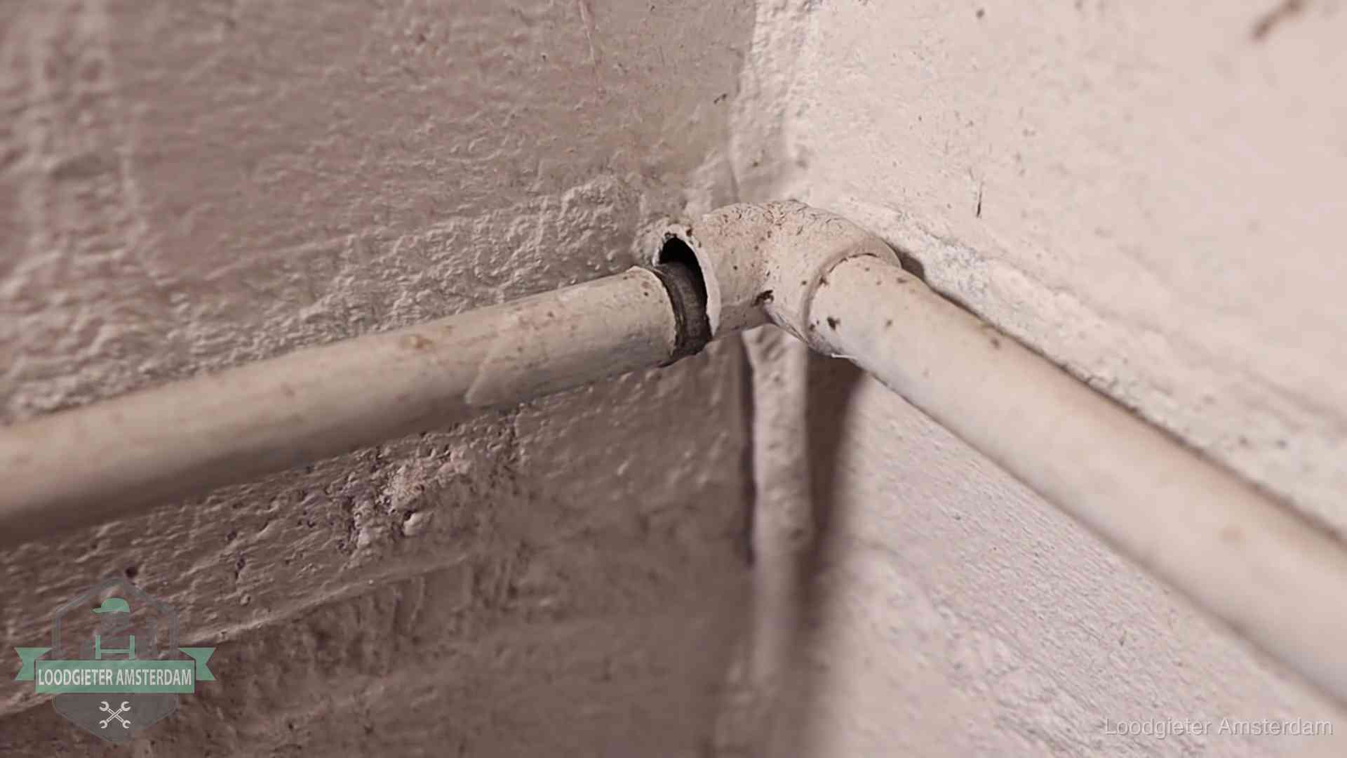 Oude waterleidingen en verborgen lekkage in Amsterdam Oude geverfde waterleiding met een losliggende fitting in een woning in Amsterdam