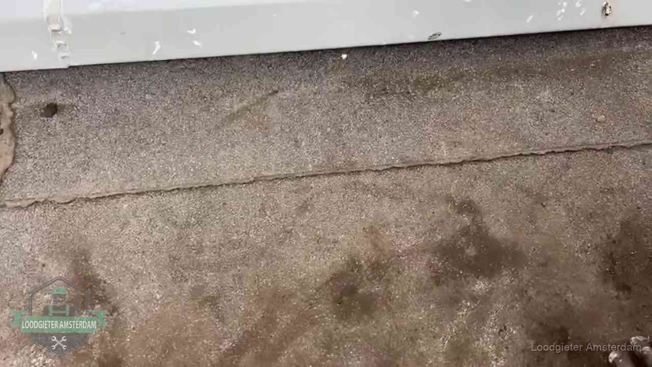 Vochtplekken bij de naad van een plat dak na aanhoudende regen in Amsterdam