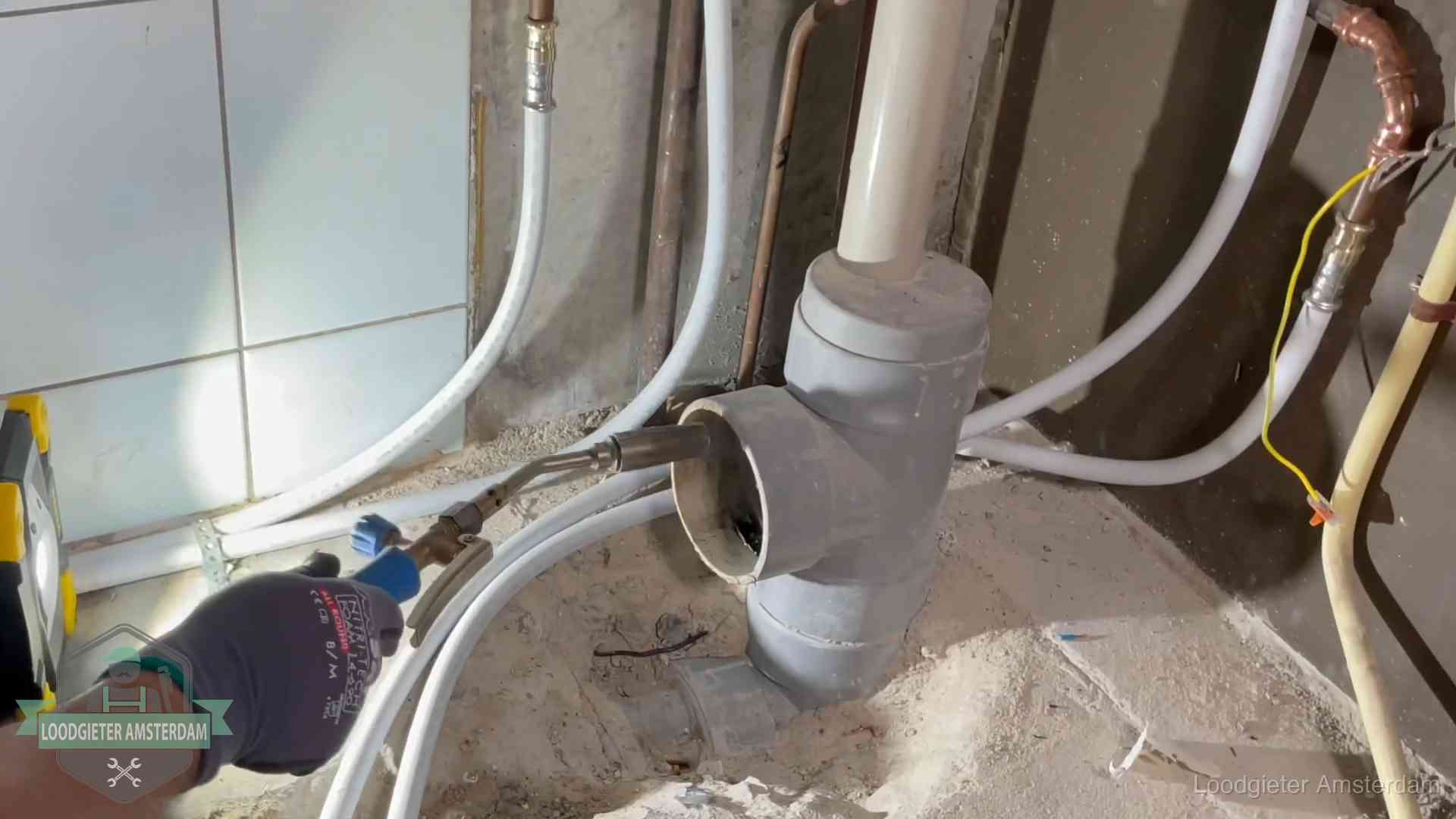 Loodgieter werkt aan leidingen bij de pvc-standleiding van een huurwoning in Amsterdam