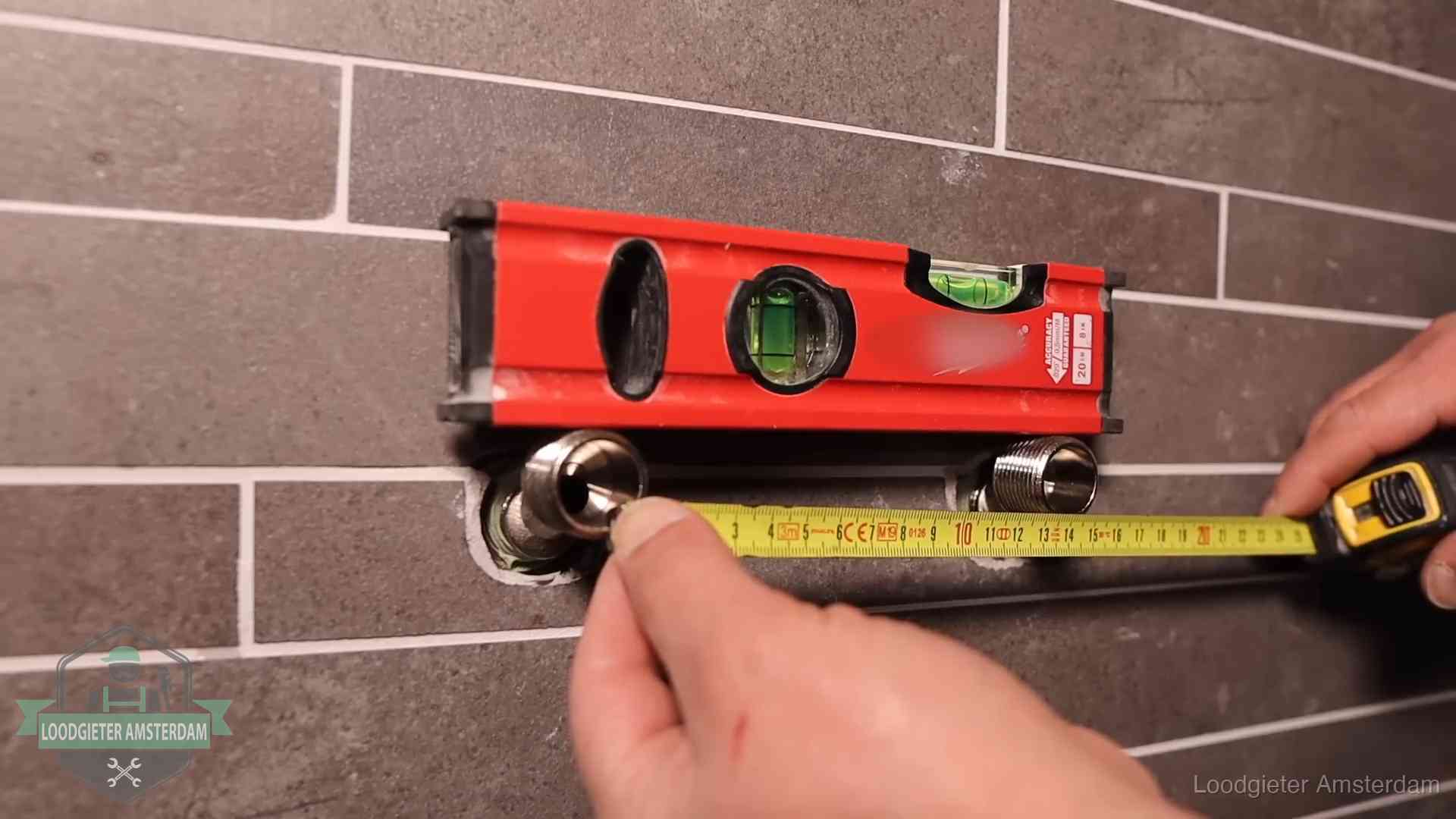 Waterpas en duimstok bij kraan-aansluitpunten in een badkamer in Amsterdam