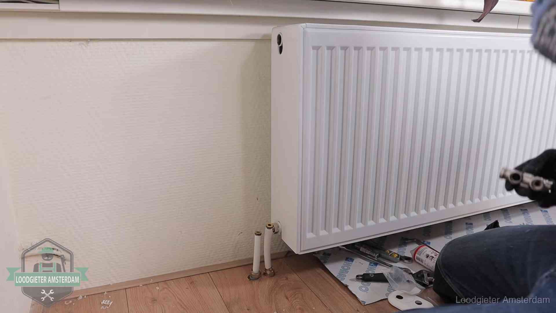 Verwarming per wijk in Amsterdam Nieuw gemonteerde radiator in een woonkamer in Amsterdam