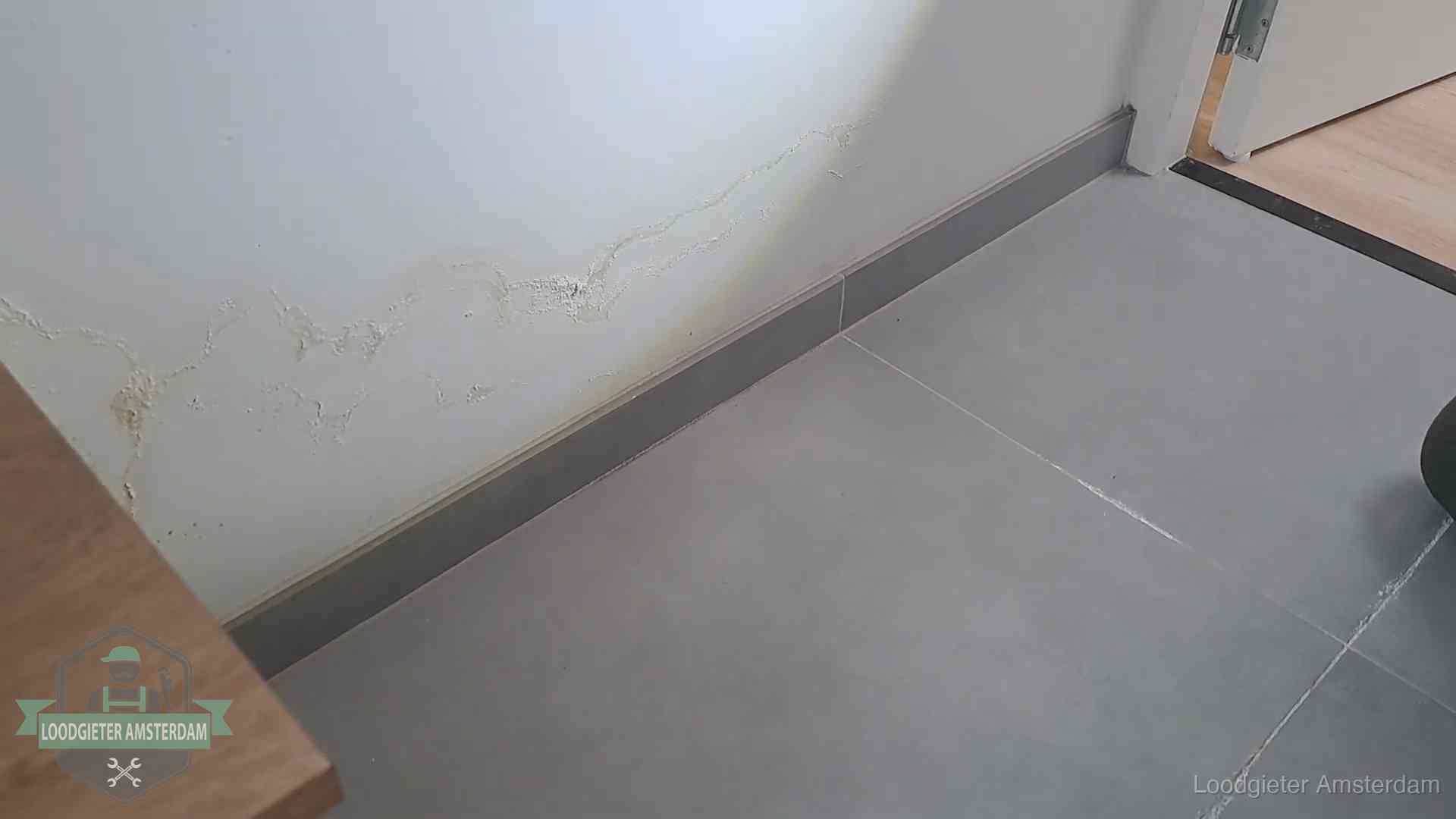Waterschade met kalkuitbloeiing op een binnenwand in Amsterdam, vastgelegd voor de verzekering