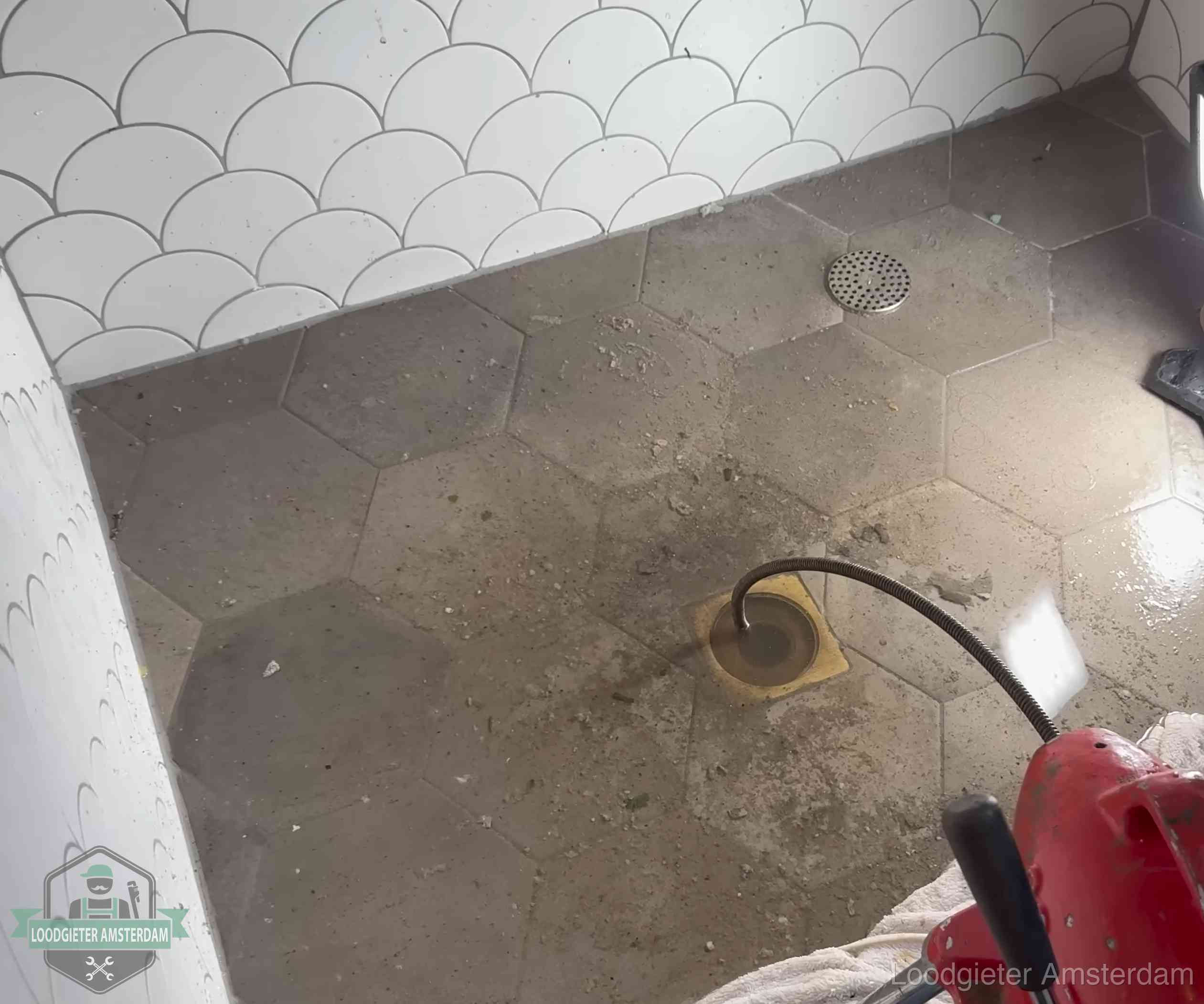 Vloerput met waterslot in een badkamer in Amsterdam, een bron van stank als het waterslot droogstaat