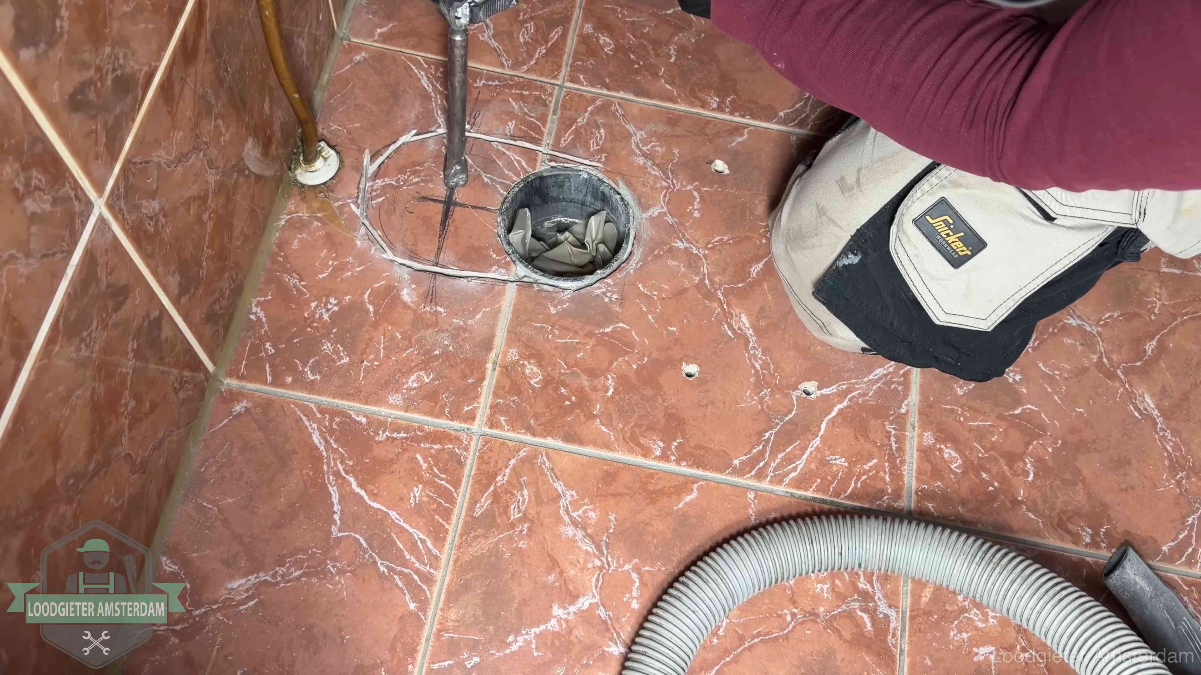 Open rioolaansluiting in de vloer waar de wc-pot is gedemonteerd in Amsterdam
